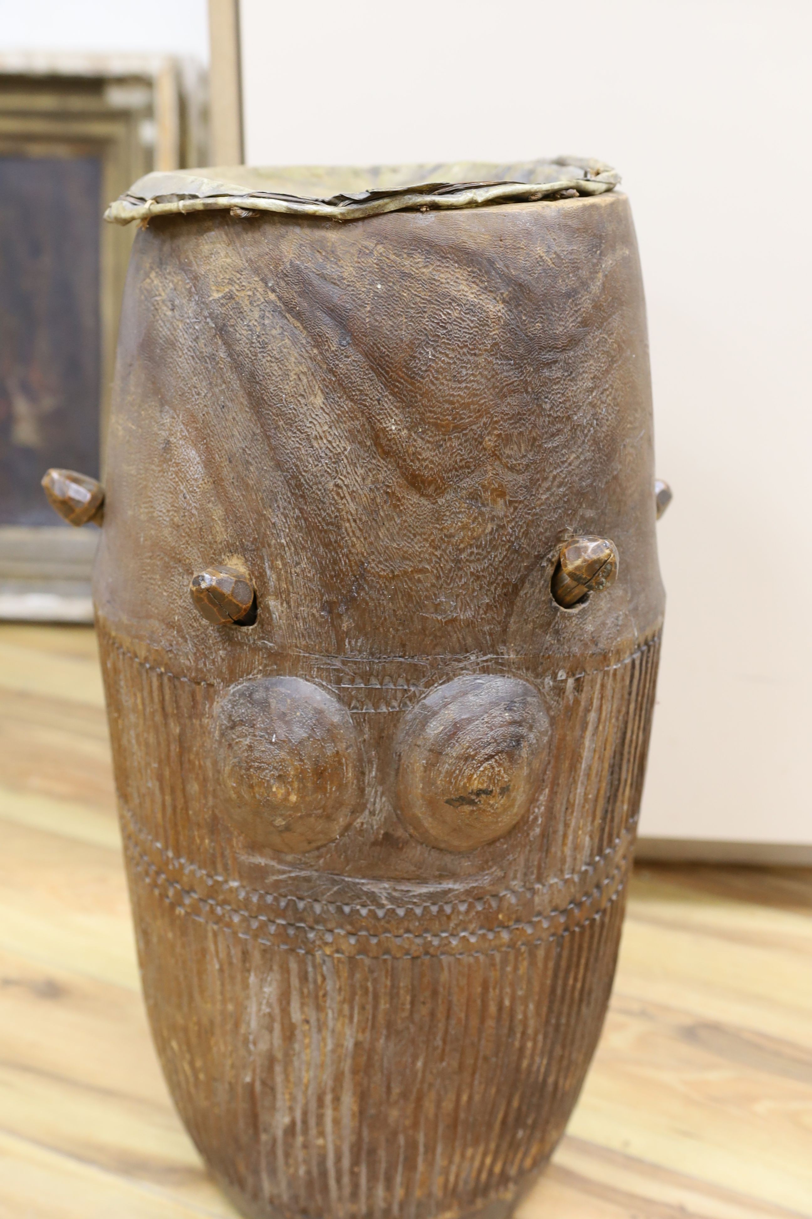 A 19th/20th century Ashanti breasted drum, 61 cms high.